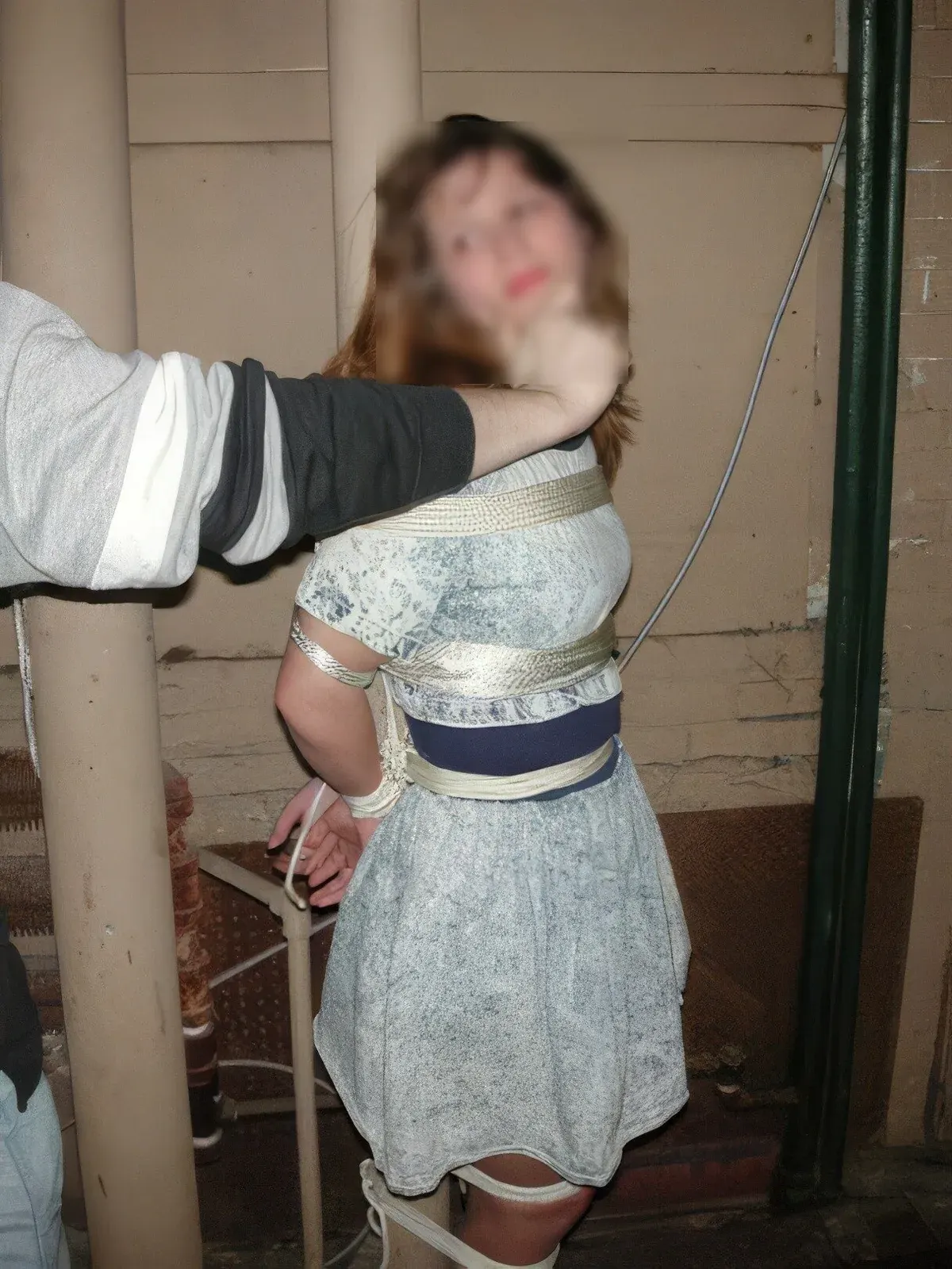 Blurred portrait of a restrained person indoors, with face obscured to support privacy in kink dating profile safety.
